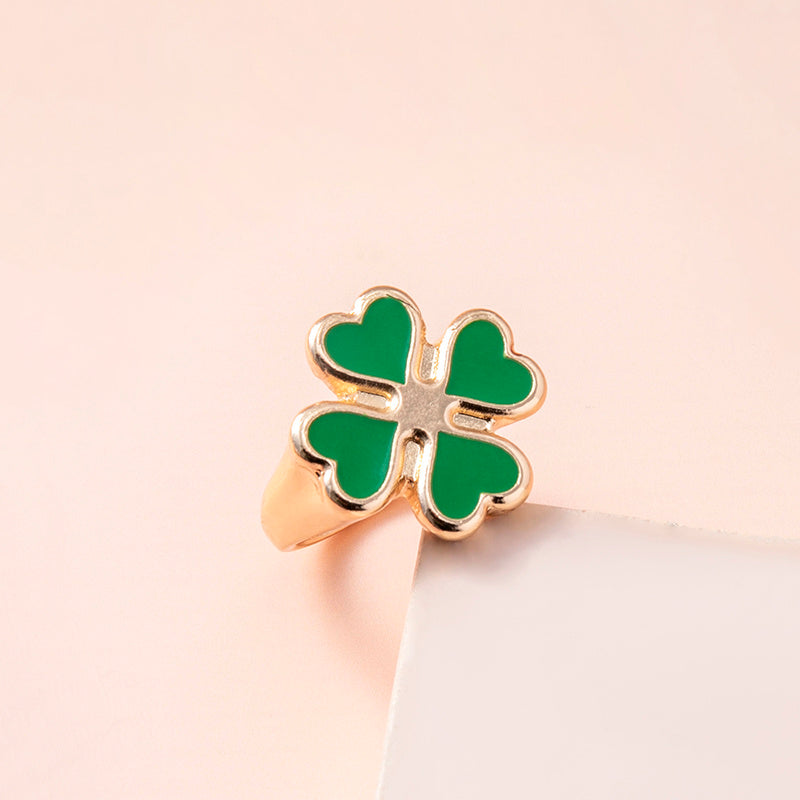 Spacewallart four leaf clover rings, delicate silver accessories with four-leaf clover charms, close-up of detailed jewelry.