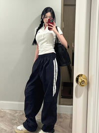 Black casual pants by Spacewallart, showing a comfortable fit with a relaxed waistband and straight-leg cut.