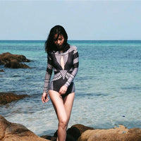 Spacewallart rash-guard swimsuit for women featuring a snug fit, vibrant design, and UV protection for active beachwear.