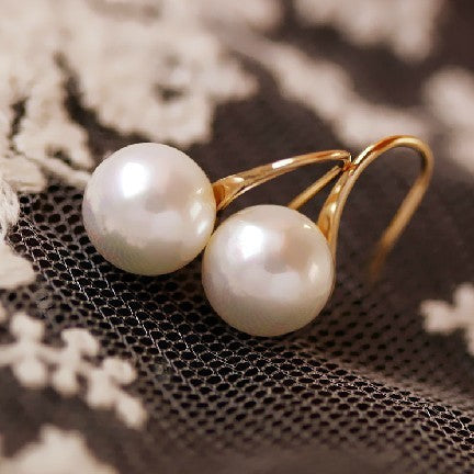 Simple pearl earrings by Spacewallart featuring classic white pearls and silver hooks, perfect for elegant accessories.