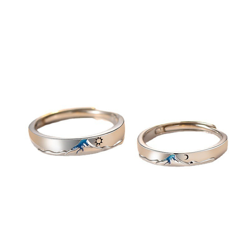 Pair of silver couple's rings from Spacewallart, showcasing polished, intertwined designs on a neutral background.
