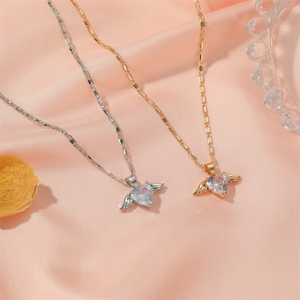 Heart Wings Necklace by Spacewallart featuring a delicate pendant with heart and wing design on a silver chain.