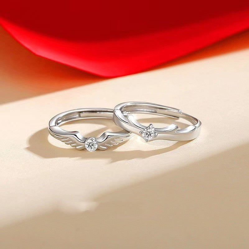 Pair of Flying Couple Rings by Spacewallart, delicate silver accessories with winged heart designs on a neutral background.