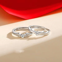 Pair of Flying Couple Rings by Spacewallart, delicate silver accessories with winged heart designs on a neutral background.