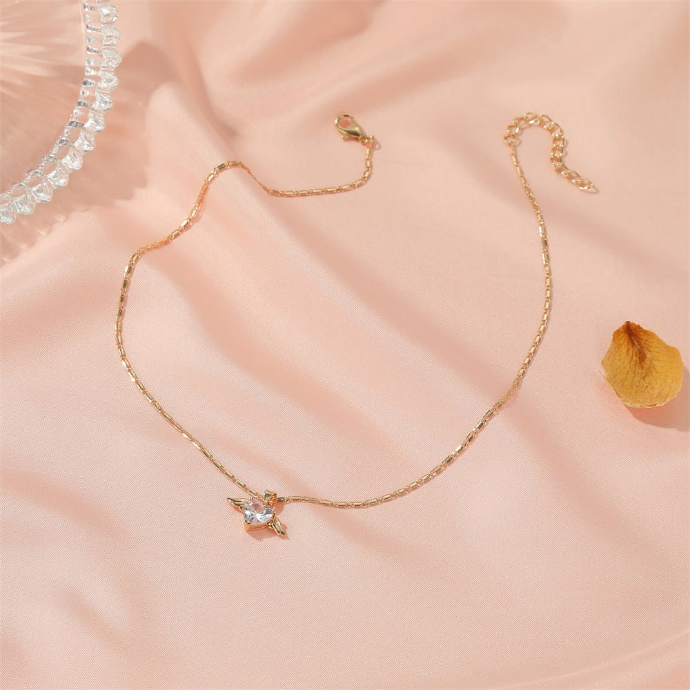 Heart Wings Necklace by Spacewallart featuring a delicate pendant with heart and wing design in silver tone jewelry.