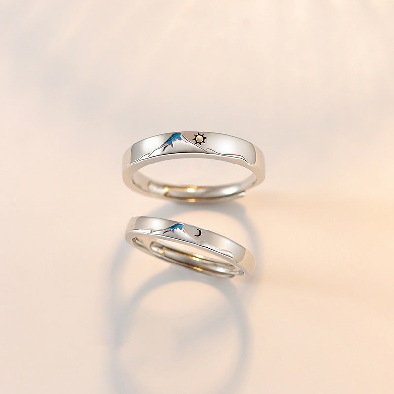 Pair of silver couple's rings from Spacewallart, shown close-up on a white background, showcasing their smooth, polished finish.