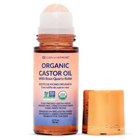 Spacewallart Queen of the Thrones Organic Golden Castor Oil Roll-On with Rose Quartz, 50ml, in a clear glass bottle with a roller applicator.